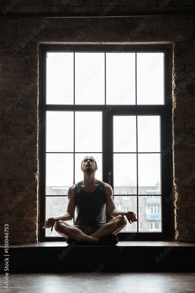 Portrait of a young concentrated sportsman meditating Portrait of a young concentrated sportsman meditating