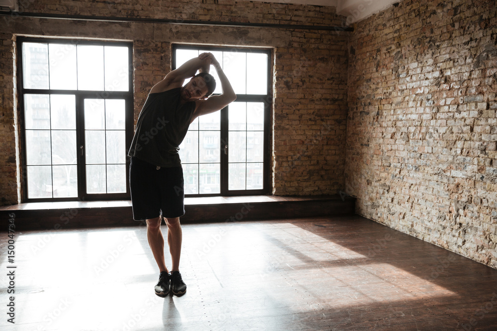 Full length portrait of a young healthy athlete man stretching Full length portrait of a young healthy athlete man stretching