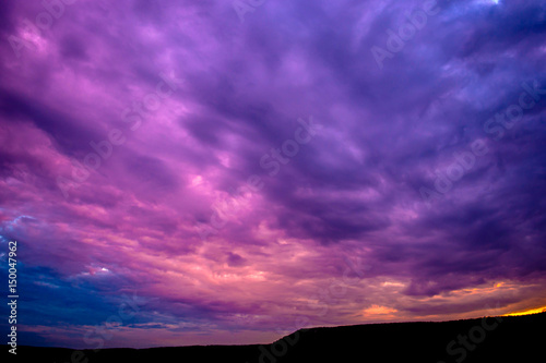 Photo of a violet sunset with clouds