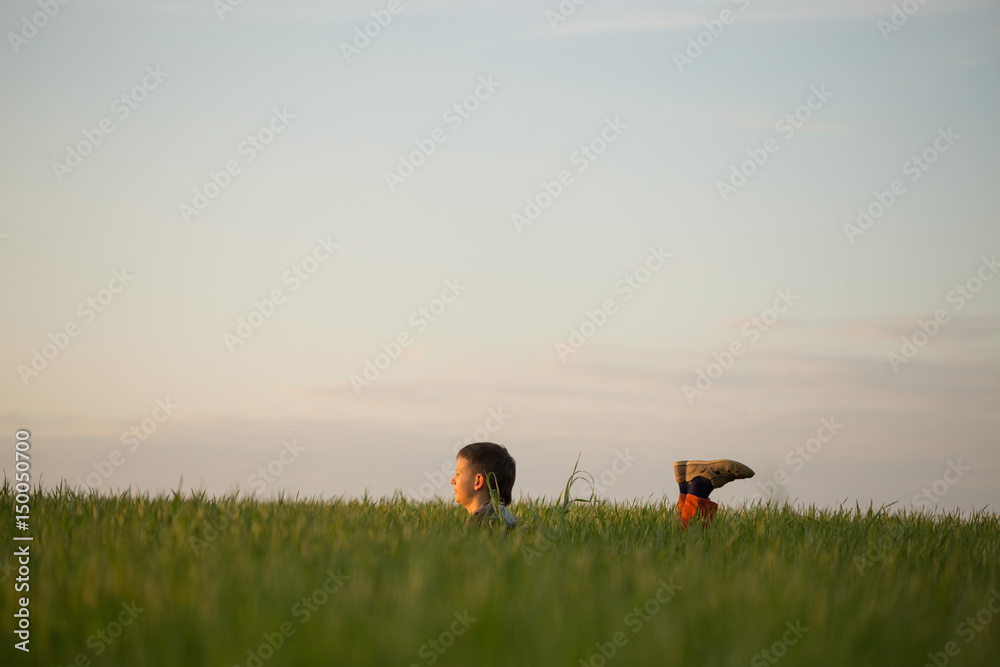 The teenager lies in the tall grass at sunset The teenager lies in the tall grass at sunset