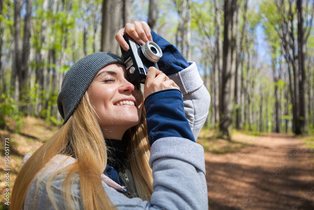Woman in park taking photos with retro film camera Woman in park taking photos with retro film camera