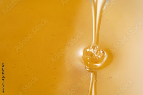 closeup of pouring organic honey with copy space, amber golden color