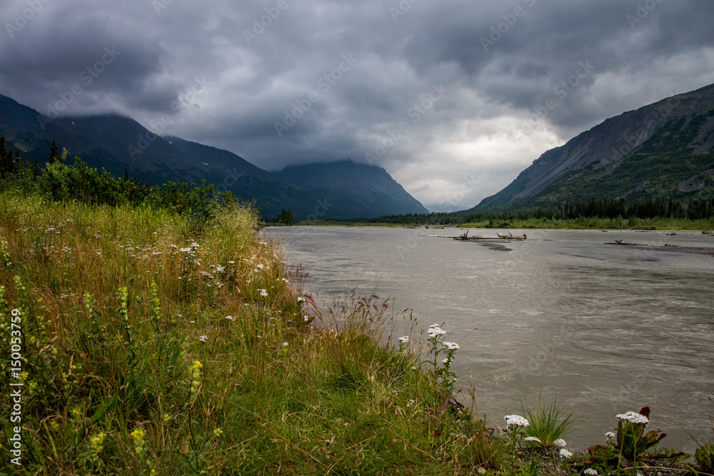 cloudy sky over mountains by river 