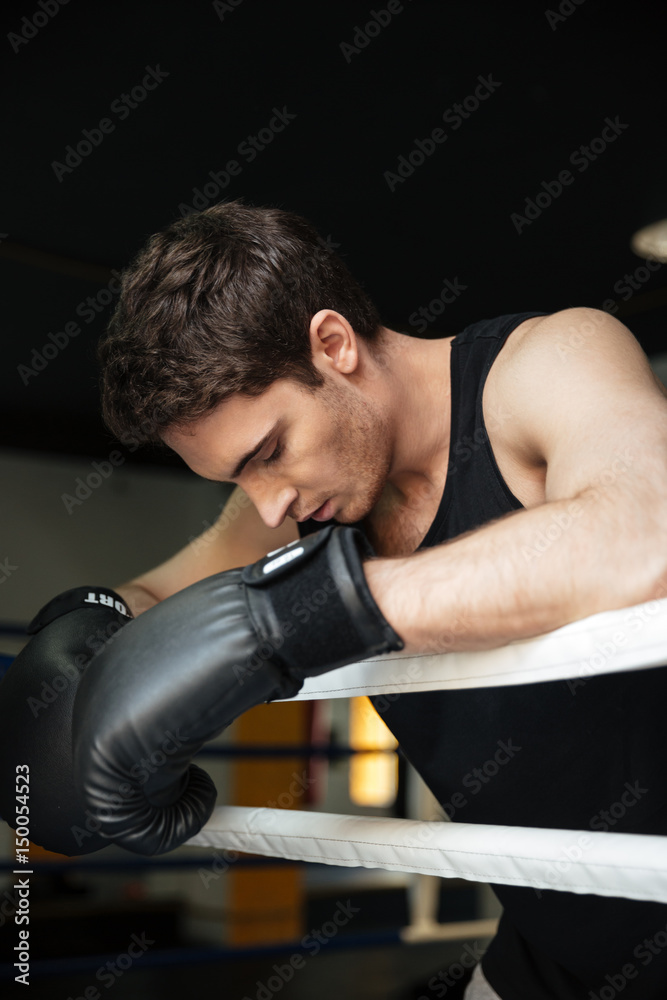Boxer training in a boxing ring. Looking aside.