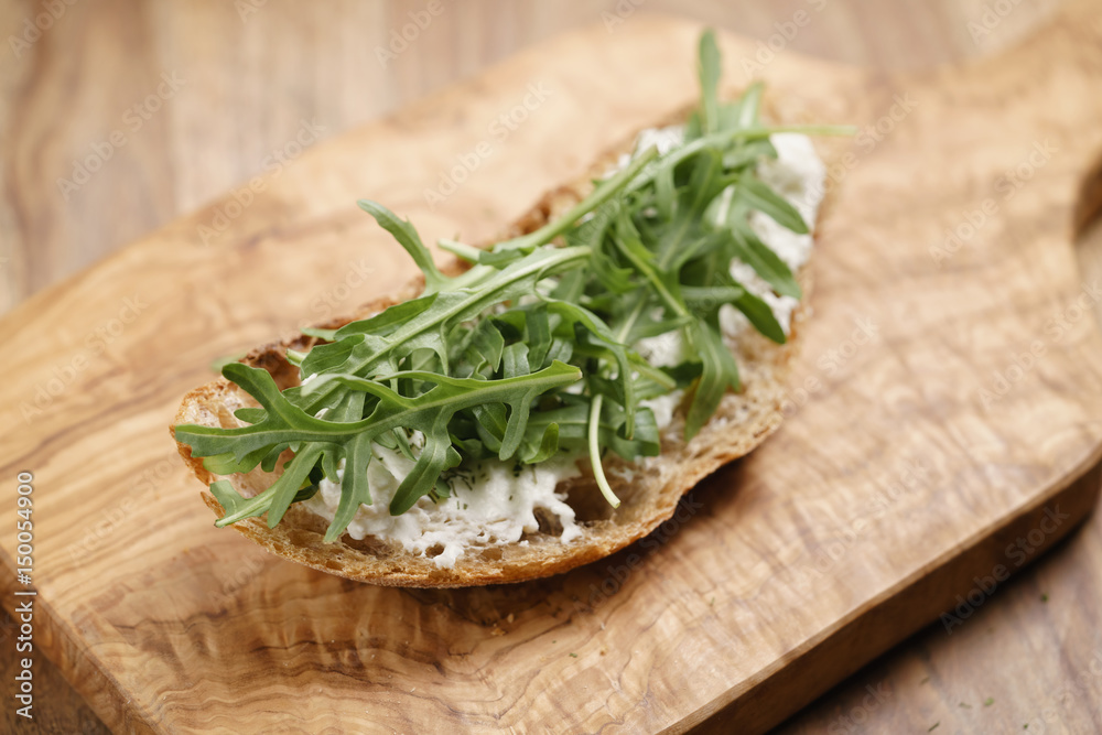 arugula on rustic bread with ricotta cheese, shallow focus