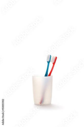 Toothbrushes in a mug on white