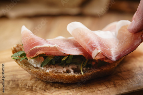 italian sandwich with speck and arugula salad, shallow focus