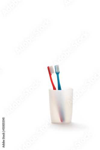 Toothbrushes in a mug on white