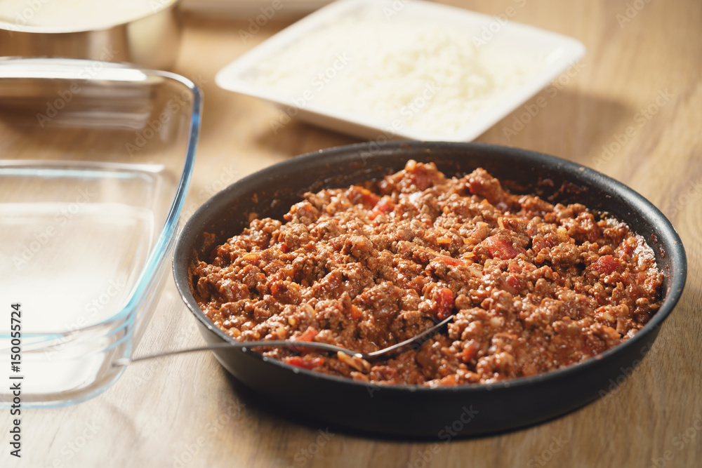 preparing lasagna process with bolognese sauce in pan, shallow focus preparing lasagna process with bolognese sauce in pan, shallow focus