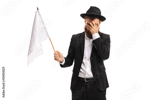 Man with a white flag holding his head in disbelief