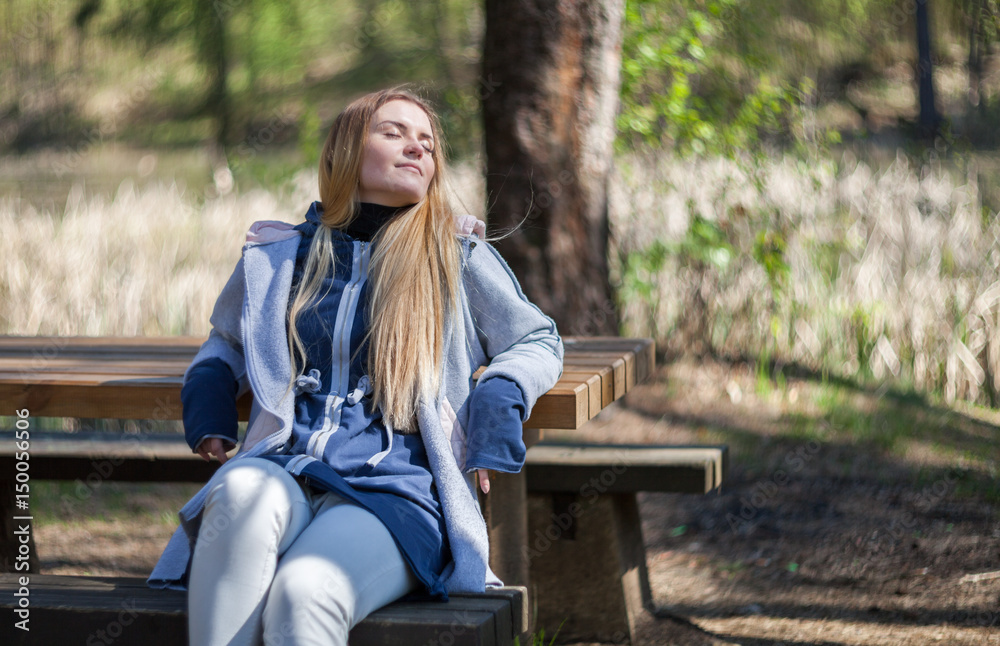 Woman enjoying sun sitting on bench in park Woman enjoying sun sitting on bench in park