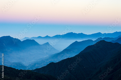 Mountain silhouettes and sunset mist over the Hoang Lien Son mountain range. On the way to Fansipan (Phan Xi Pang) - the highest mountain in Indochina located in Lao Cai Province, Vietnam