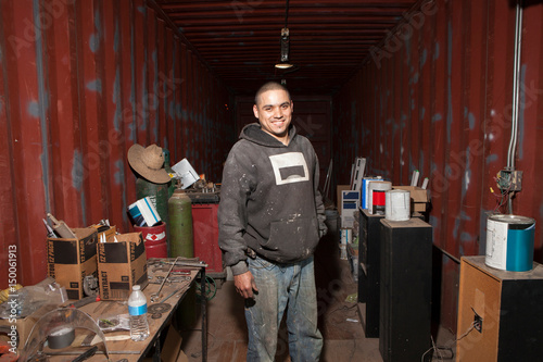 Portrait of builder in shipping container looking at camera smiling