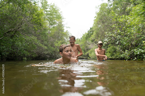 Teenage boys swimming in lake, Niceville, Florida, USA photo