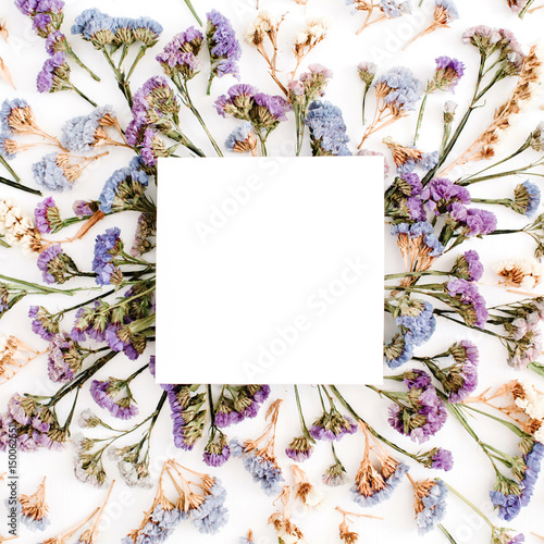 Fototapeta Naklejka Na Ścianę i Meble -  Empty white paper blank on blue and purple dried flowers frame on white background. Flat lay, top view