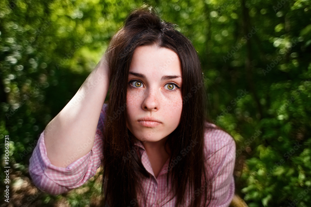 Portrait of attractive young pensive perplexed woman face close up