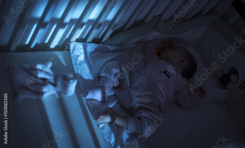 Adorable baby sleeping in blue at night