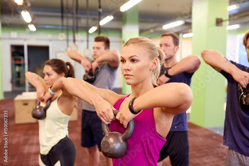 Fototapeta Naklejka Na Ścianę i Meble -  group of people with kettlebells exercising in gym