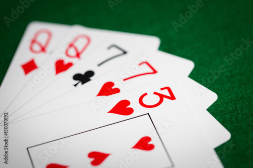 poker hand of playing cards on green casino cloth