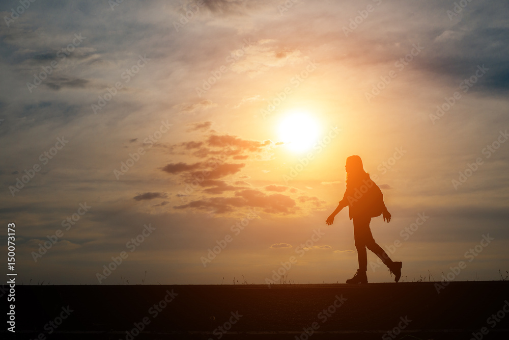 Silhouette of young woman traveler with sunset.
