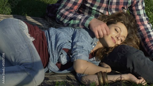 young girl lying in the lap of her boyfriend and resting in nature