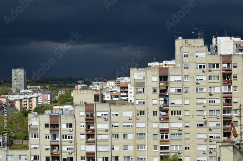 Stormy dark blue sky above a quarter of residential buildings © branislav