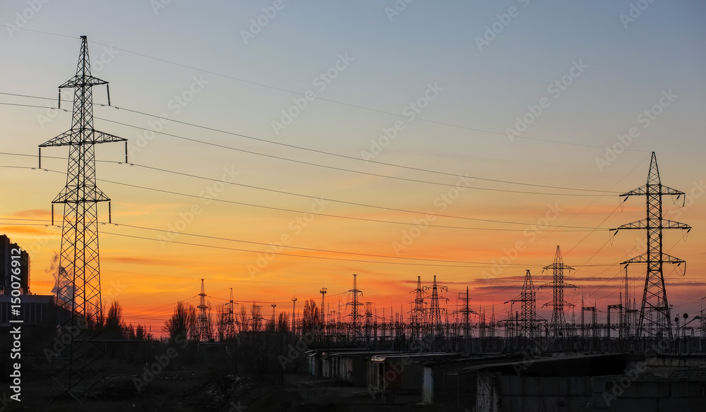 Electricity Pylons and Power Lines on sunset sky background