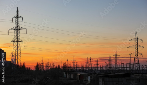Electricity Pylons and Power Lines on sunset sky background