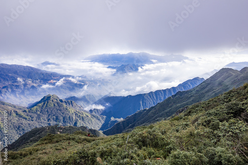Valley covered with clouds. View from Fansipan - the highest mountain in Indochina located in Sapa, Hoang Lien Son mountain range, Lao Cai Province, Vietnam © andrii_lutsyk