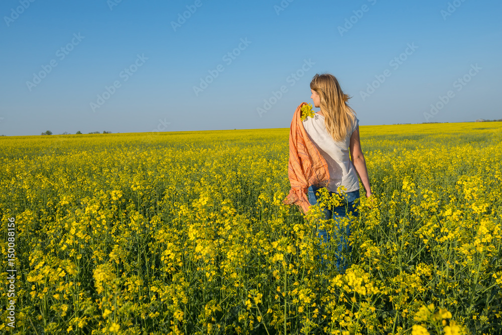 Beautiful young woman, blonde with flying hair is walking through a field Beautiful young woman, blonde with flying hair is walking through a field
