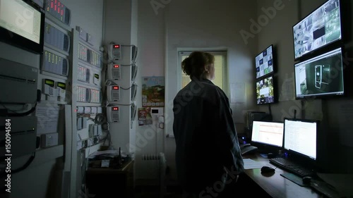Female operator Looking At Multiple Camera Footage On Computers