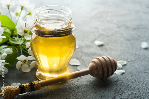 Honey with blossoms and wooden spoon