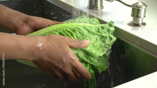 Washing lettuse in the sink. Slow Motion. photo