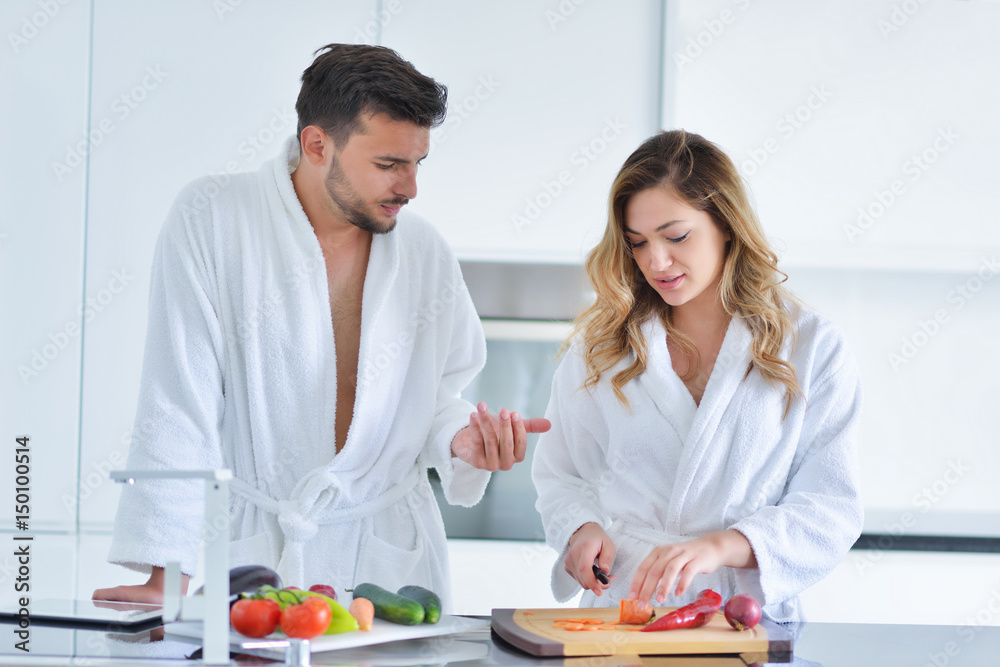 Happy couple cooking breakfast together in the kitchen Happy couple cooking breakfast together in the kitchen