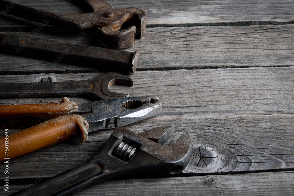 Dirty set of hand tools on a wooden background. Old rusty tools. Equipment for locksmith and metalworking shop. Sales tools for assembly workers. Old shop Old working tools. Vintage working tools (dr Dirty set of hand tools on a wooden background. Old rusty tools. Equipment for locksmith and metalworking shop. Sales tools for assembly workers. Old shop Old working tools. Vintage working tools (dr