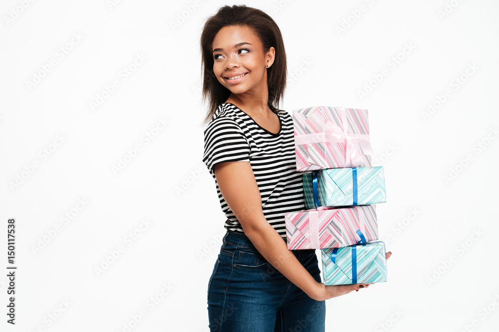 Smiling happy african woman holding stack of present boxes Smiling happy african woman holding stack of present boxes
