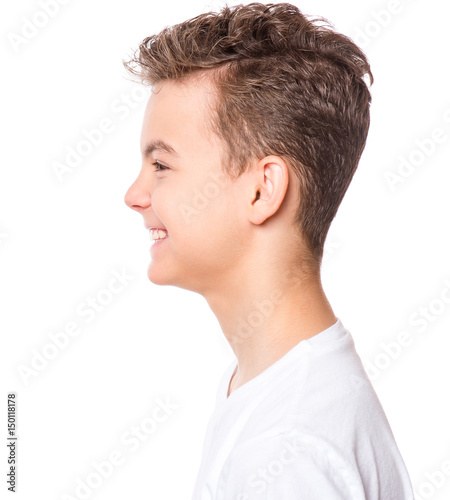 White t-shirt on teen boy. Profile of handsome caucasian smiling child, isolated on a white background. Concept of childhood and fashion design. 