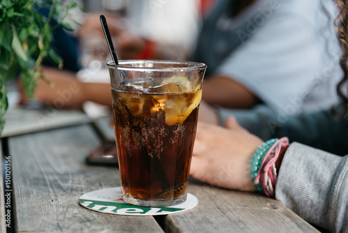 Foto Refreshing glass of cola on wooden table in a bar