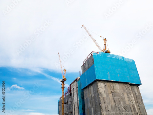Obraz na płótnie Crane and building construction,
High-rise building under construction w salonie