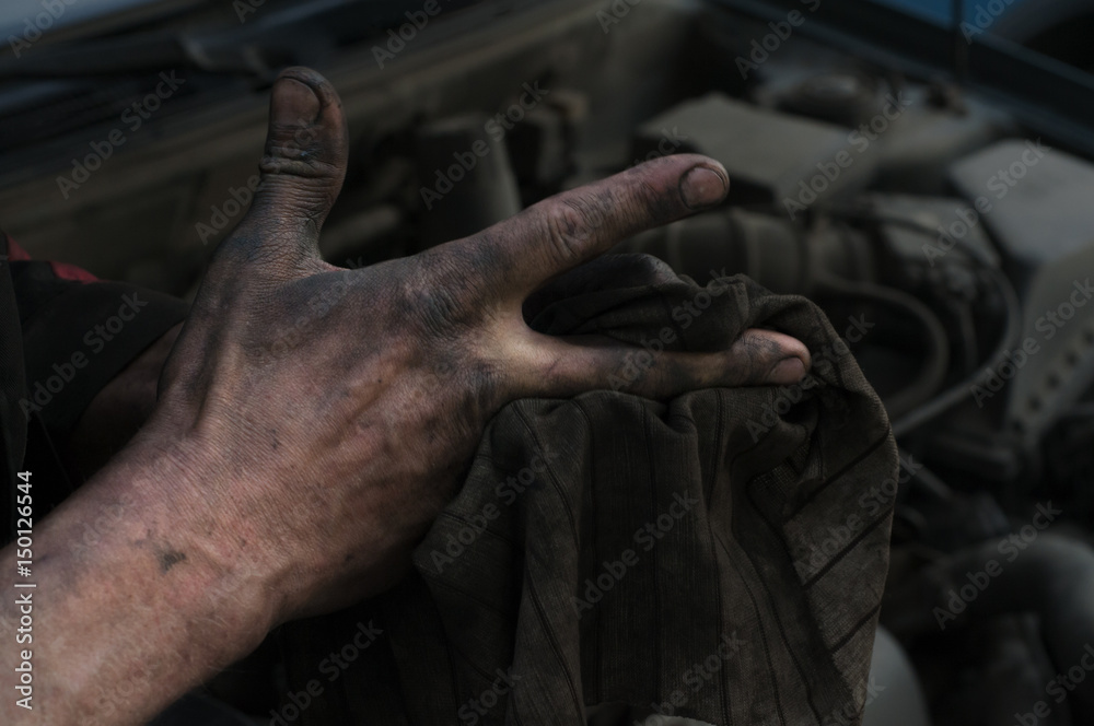 The repairman of cars wipes hands a rag