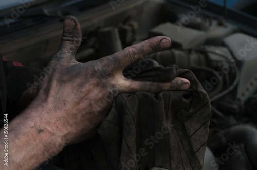The repairman of cars wipes hands a rag