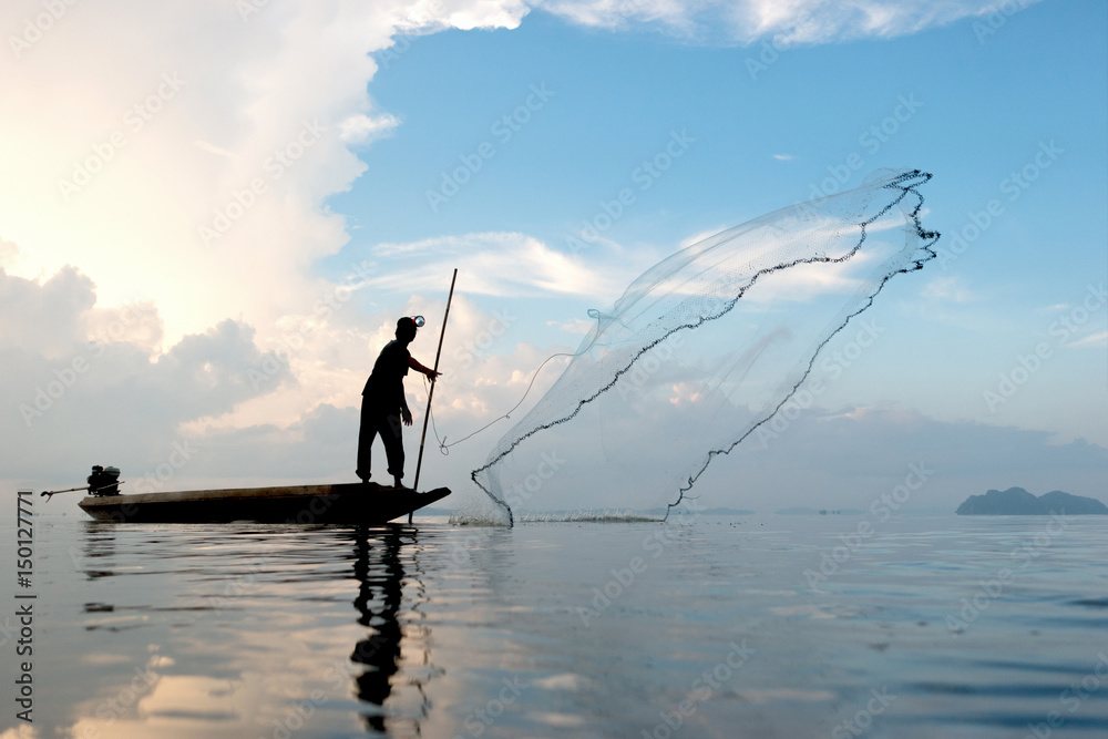Fisherman throwing fishing net during sunrise in Pak Pra Village,  Phatthalung, Thailand Stock Photo