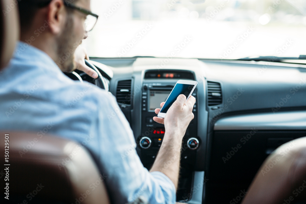 Businessman ignoring safety and texting onmobile phone while driving Businessman ignoring safety and texting onmobile phone while driving