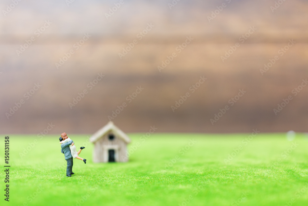 Miniature bamboo house and couple on green yard