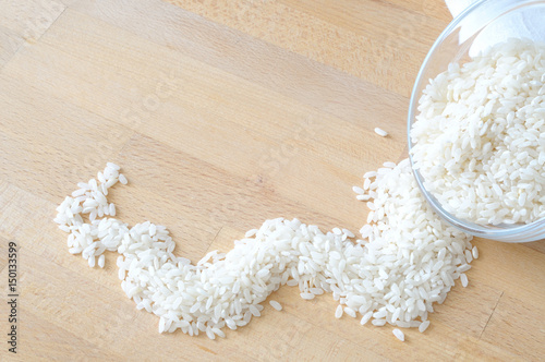Rice overturned from a bowl on a wooden table