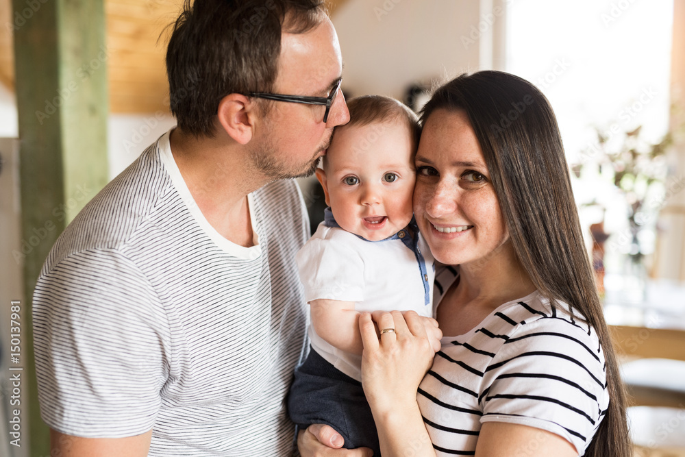 Beautiful young parents holding their cute baby son