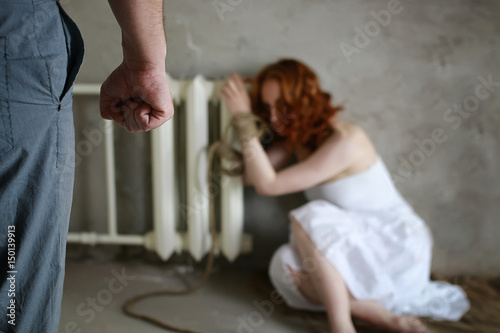 Принти на полотні Girl victim of kidnapping sits tied on the floor in white shirt