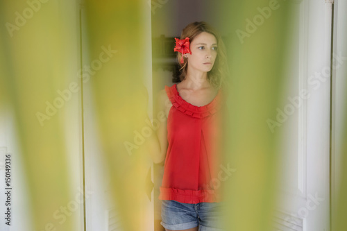 Portrait of a girl in red shirt with a flower