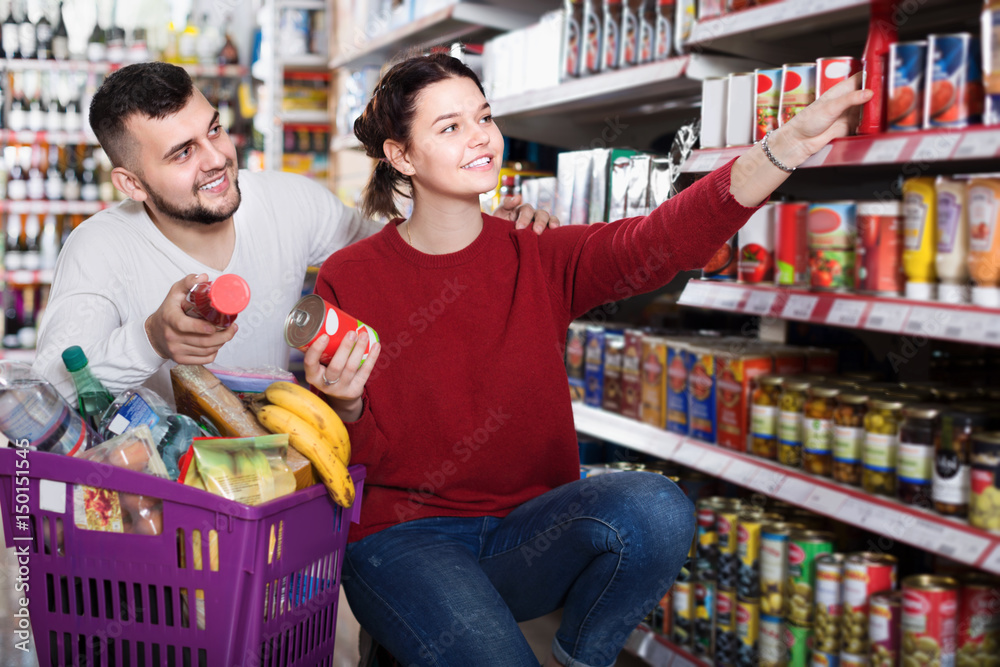 Couple purchasing tinned food at grocery shop