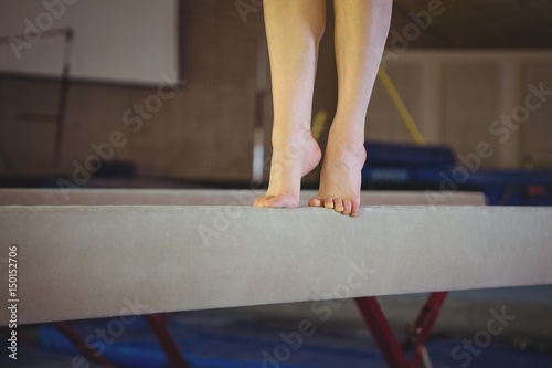 Female gymnast practicing gymnastics on the balance beam